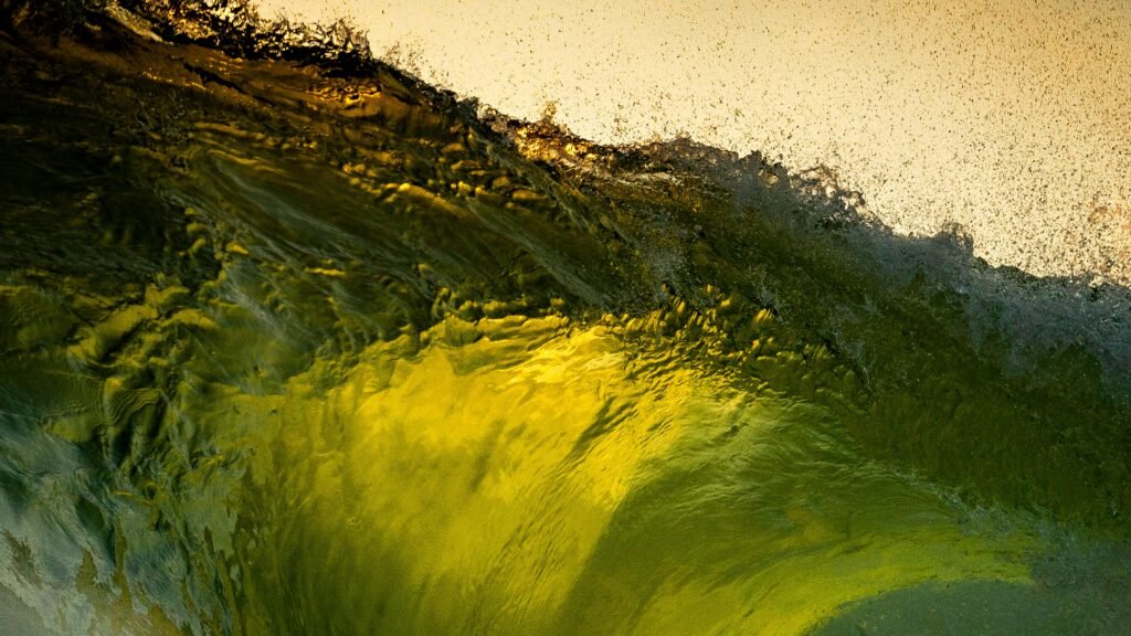 Close-up of a dynamic wave cresting over a sandy shoreline in Chile, capturing the vibrant play of light and color.
